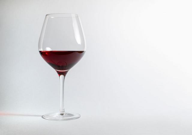 Trois verres à vin de formes différentes posés sur une table